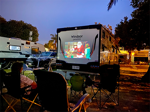 Windsor caravan with projector movie playing on the side at night